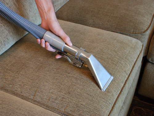 Material couch being professionally cleaned